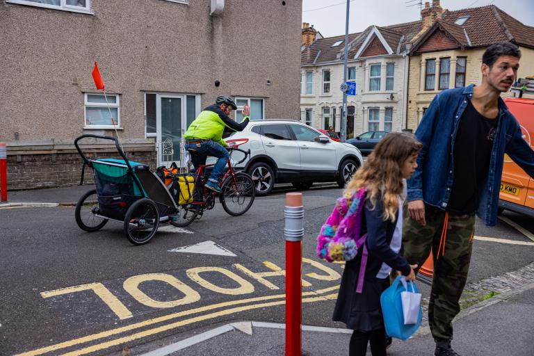 Man walking young girl into school in Bristol.