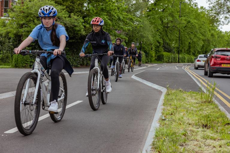 Teen children cycling on a segregated cycle path in Binley, Coventry.