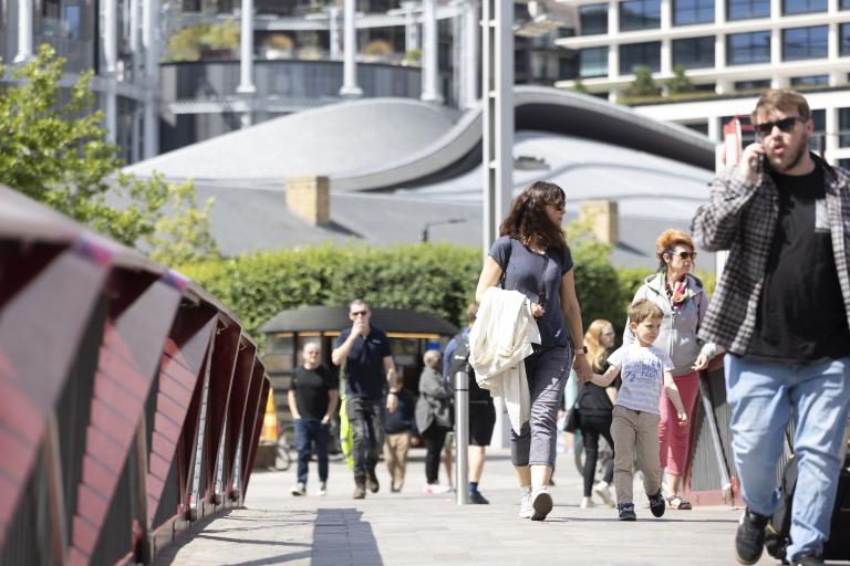 Family with child walking in Granary Square, London.