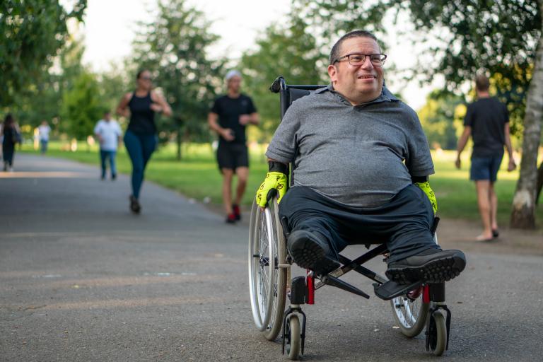 Older man using wheelchair in park, unknown location