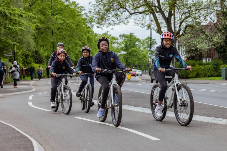 A group of children cycle on a segregated cycle path