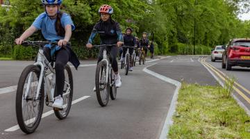 Teen children cycling on a segregated cycle path in Binley, Coventry.