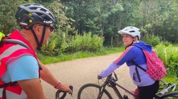 A man and woman on cycles wearing helmets