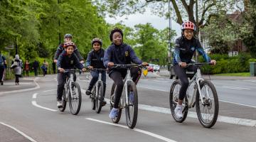 A group of children cycle on a segregated cycle path